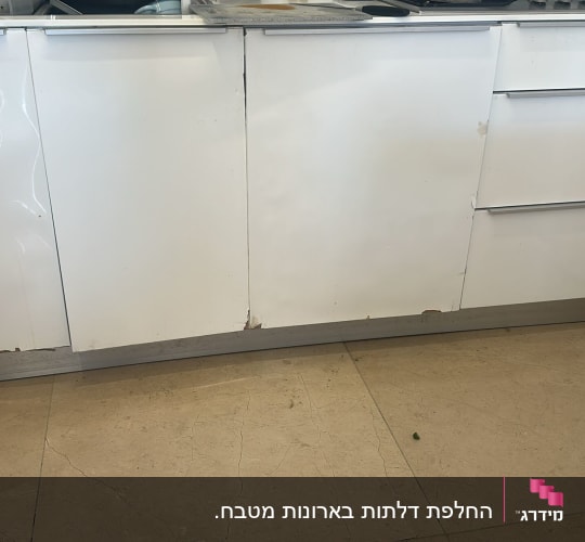 ארונות מטבח לבנים עם סימני בלאי בתחתית